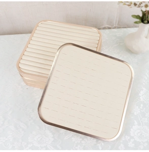 Detail view of beige velvet jewelry tray with gold metal frame for rings and earrings