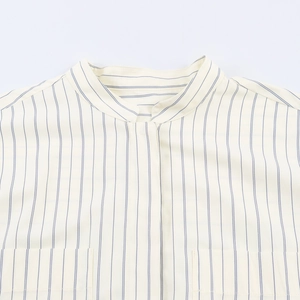 Detail of band collar and chest pockets on a beige blue striped cotton shirt