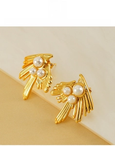 Detail of 18K gold plated swallow wing earrings with three inlaid white pearls