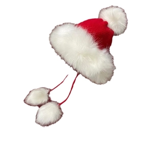Red knit Christmas trapper hat with white faux fur trim and festive hanging pom-poms