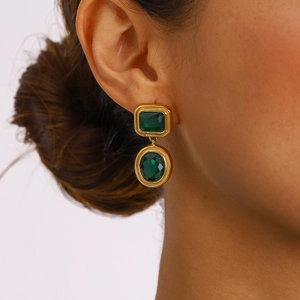 Vintage gold-plated earrings with emerald green rectangular and oval stones on model