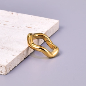 Detailed macro view of a vintage gold wavy stainless steel ring on a stone base
