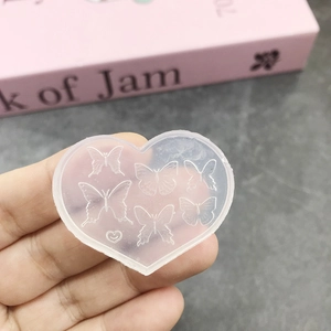 Detailed view of heart-shaped silicone mold featuring delicate butterfly patterns for DIY nail art