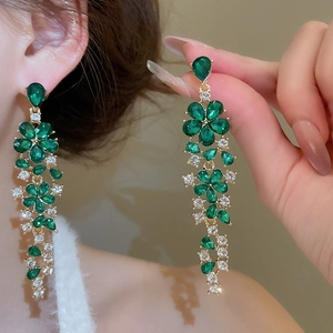 Golden drop earrings with green zircon and tassels featuring a bow and floral design