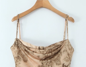 Détail de robe en satin champagne avec imprimé floral vintage et col bénitier