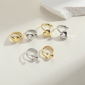 Detailed close-up of gold and silver heart-shaped rings and beaded ear cuffs
