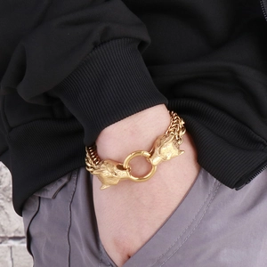 Detailed view of men's double layer gold chain bracelet featuring two wolf head charms