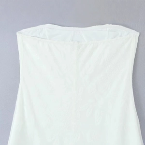 Élégant haut bustier en dentelle blanche avec texture jacquard sur fond gris neutre