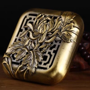 Detailed close-up of antique brass incense burner lid with 3D chrysanthemum carvings