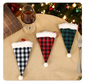 Plaid Christmas cutlery holders with white plush trim on golden festive tablecloth