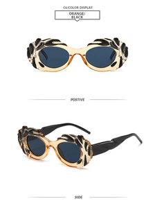 Dettaglio occhiali da sole cat-eye arancioni con rilievo a fiamma nera in stile 3D