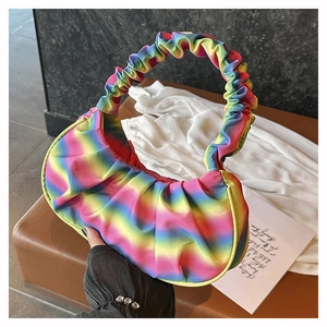 Detail of colorful rainbow gradient pleated handbag with soft cloud texture and glossy finish