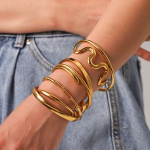 Detail of 18K gold plated stainless steel bangles set with bamboo and wave textures