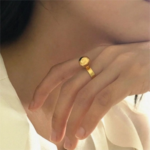 Polished gold beaded ring on model hand featuring a minimalist round sphere design