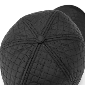 Macro detail of black quilted baseball cap crown with diamond stitching and top button