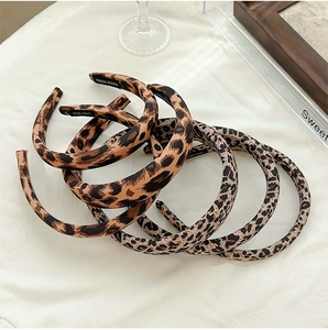 Detail of leopard print sponge headband with handmade craftsmanship label on white fabric