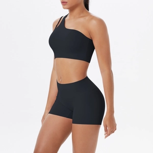 Detail von schwarzem Ein-Schulter-Sport-BH und High-Waist-Shorts zeigt den Materialstoff