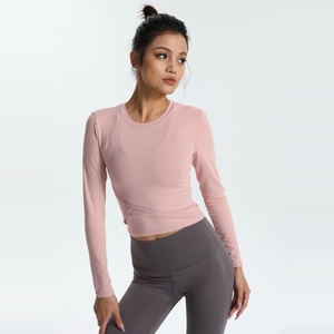 Haut de yoga à manches longues rose tendre avec détail croisé à la taille et col rond