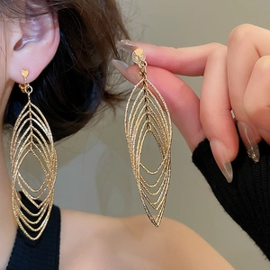 Macro shot of gold layered hollow leaf ear clips featuring detailed brushed metal texture