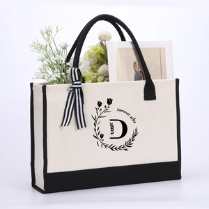 Close-up of cotton canvas tote bag with letter D print and striped ribbon detail