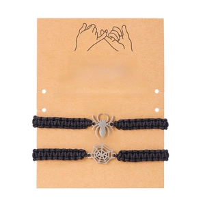 Detail of handmade black woven Halloween spider and web bracelets on brown kraft card