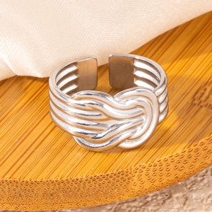 Detail view of silver knot ring showing braided cable design on a bamboo base