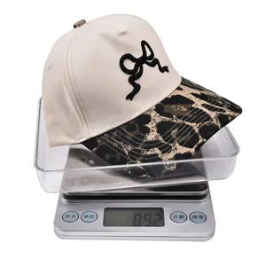 Dettaglio del cappellino ricamato leggero con peso di 89,2g sulla bilancia digitale