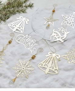 Detailed flat lay of festive gold and silver metal Christmas tree ornaments on white snow