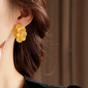 Détail de la boucle d'oreille florale texturée en plaqué or 18K sur le mannequin