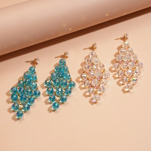 Detailed shot of long tassel earrings with blue and clear crystal beads in gold metal