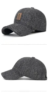 Detail view of winter baseball cap showing thick gray tweed texture and leather patch