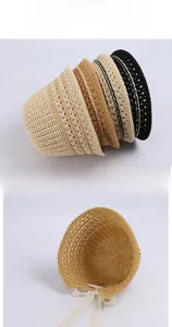 Detailed view of hollow knit summer sun hat with elegant lace ties and woven texture