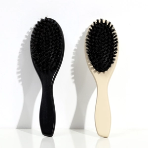 Detail of wooden hairbrushes with natural boar bristles in black and beige colors