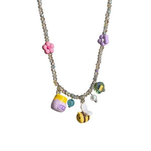 Charming beaded necklace featuring colorful flowers, honey pot, and bee charms on white background