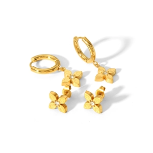 Gold clover stud earrings with sparkling crystals and textured details on white base