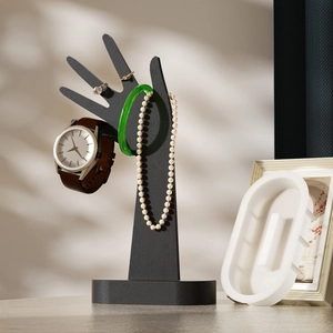 Portagioie a forma di mano nero opaco con anelli, orologio e collana su vassoio