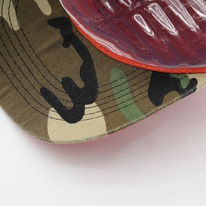 Close-up of camouflage baseball cap brim with durable stitching and red piping detail