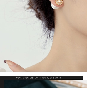Close-up of elegant double-sided pearl earrings with gold metal and cubic zirconia