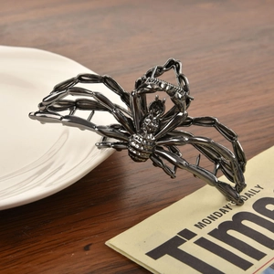 Macro detail of gothic spider hair claw clip in gun black metal finish on desk