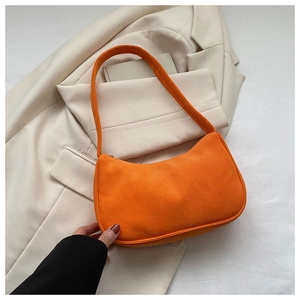 Detail of orange corduroy baguette bag texture and minimalist crescent underarm design