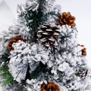 Pomme de pin naturelle avec neige artificielle sur branche de sapin enneigée