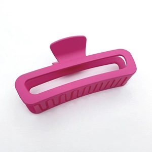 Close-up of a matte fuchsia rectangular hair claw clip on white fabric background