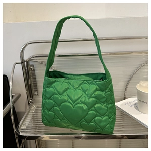 Détail de la texture matelassée en forme de cœur sur le sac fourre-tout vert