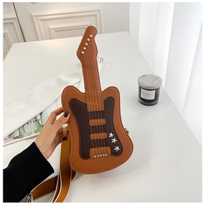 Close-up of creative guitar-shaped crossbody bag with metal rivets and star details