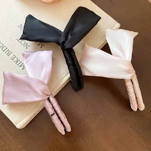 Trois élégantes pinces à cheveux banane avec nœuds en satin noir, rose et beige