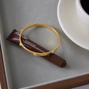 Detailed view of hammered 18K gold plated stainless steel bangle with white zircons