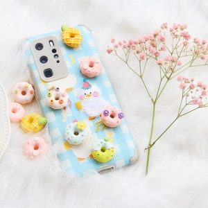Blaue karierte Handyhülle mit 3D-Harz-Donuts und Enten-Anhänger auf weißem Plüsch