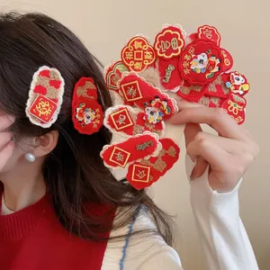 Plush red New Year hair clips with traditional embroidery and lucky cat motifs