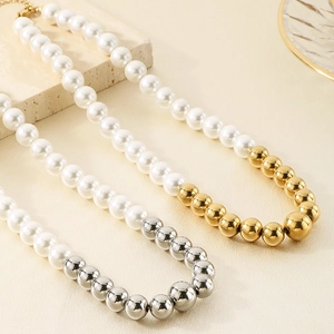 Dettaglio delle sfere di metallo lucido e perle bianche lucenti sulla collana elegante