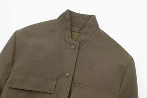 Detail of army green flight jacket showing ribbed stand collar and metal snap buttons